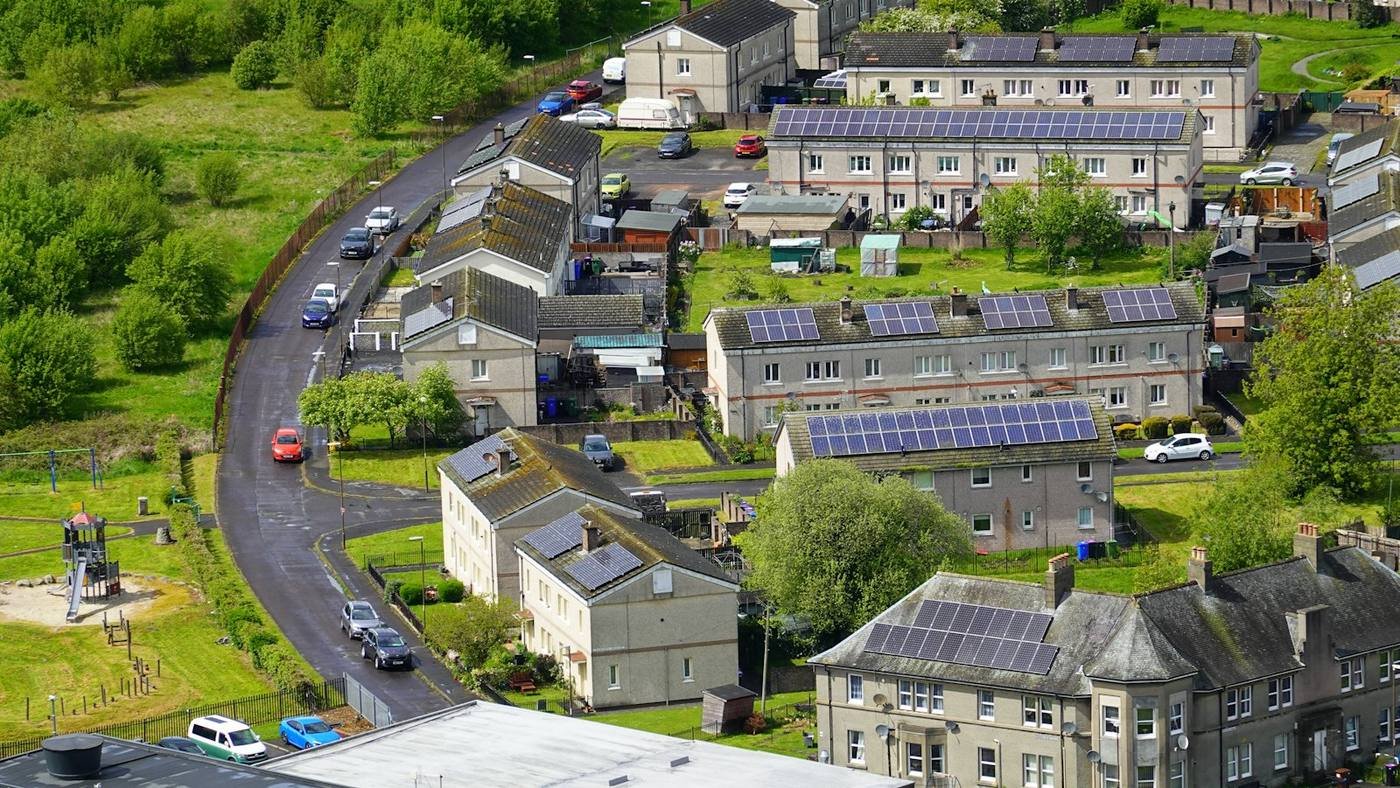 Aerial view of a residential neighbourhood with solar panels on many rooftops